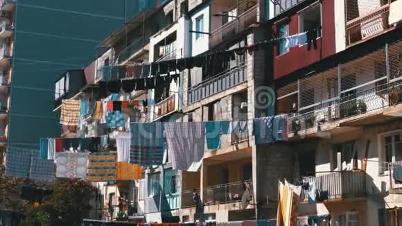 城市贫困地区一栋多层建筑上的一根绳子上挂着和烘干的衣服视频的预览图