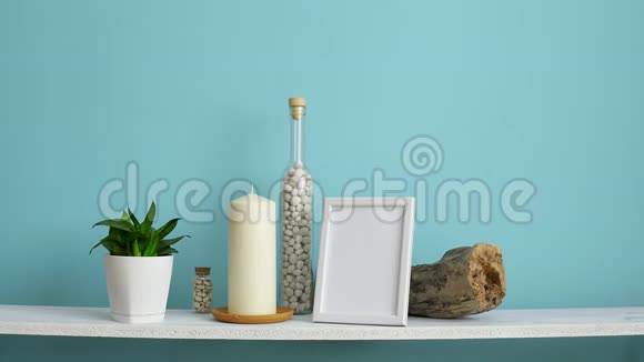 现代客房装饰与相框模型白色的架子靠在粉绿色的墙上瓶中有蜡烛和岩石手视频的预览图