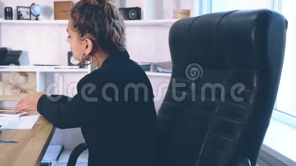 女孩穿着时髦的衣服坐在办公室里视频的预览图