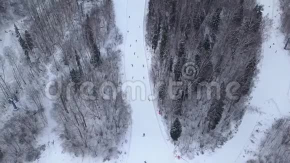 冬季滑雪板在滑雪场无人驾驶飞机视野的雪坡上冬季活动视频的预览图