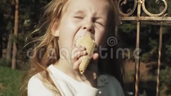 一个可爱的女孩坐在公园里吃冰淇淋视频的预览图