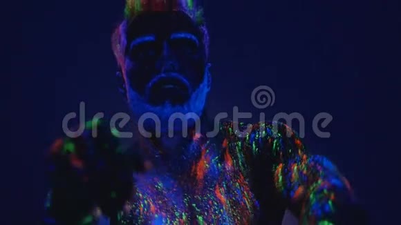在紫外线下跳舞一个人在紫外线下不真实的舞蹈强壮肌肉发达的男人是个脱衣舞娘视频的预览图