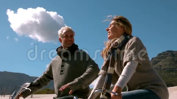 快乐的成熟夫妇去海滩骑自行车视频的预览图