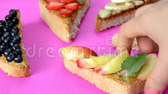 不同的美味烤面包在绿色或粉红色深红色背景健康三明治作为早餐或零食一起吃烤面包视频的预览图