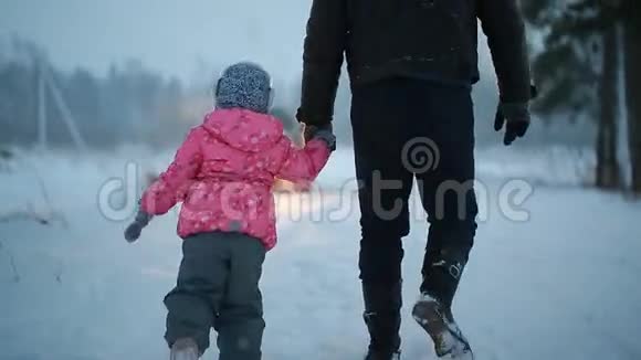 爸爸和女儿在冬天的公园里玩得很开心视频的预览图