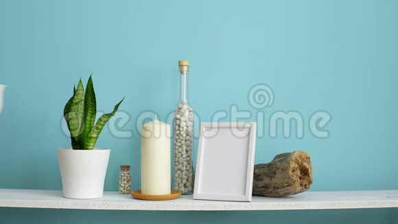 现代客房装饰与相框模型白色的架子靠在粉绿色的墙上瓶中有蜡烛和岩石手视频的预览图