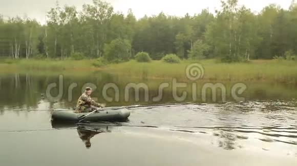 渔夫在一艘充气船上漂浮在湖面上清晨视频的预览图