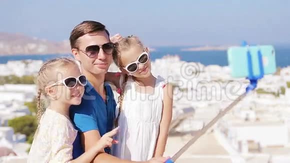 家庭度假在欧洲父亲和孩子自拍背景Mykonos镇希腊视频的预览图