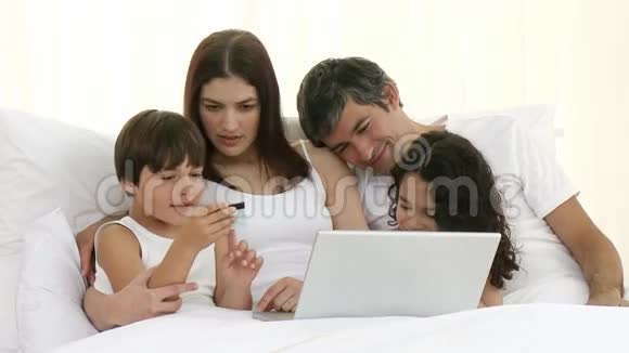 家长和儿童在床上网上购物视频的预览图