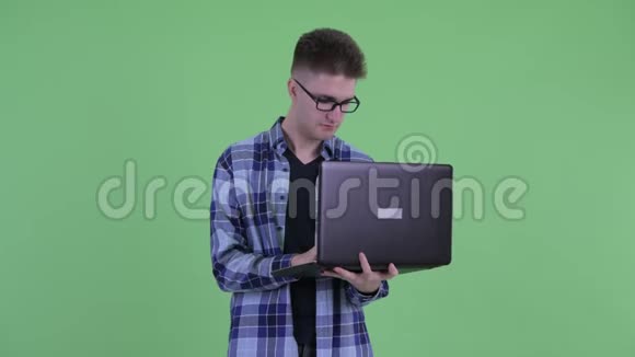 快乐的年轻潮男在使用笔记本电脑时思考视频的预览图