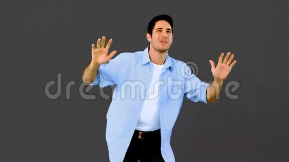 男人在灰色背景下跳舞玩得开心视频的预览图