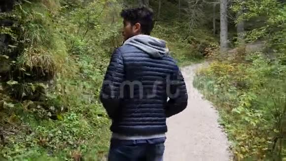 年轻人在郁郁葱葱的青山上徒步旅行视频的预览图