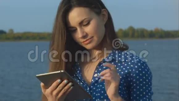 女士户外使用数字平板电脑视频的预览图