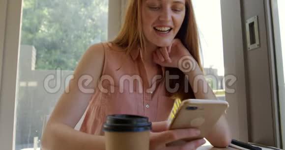 在咖啡馆里用智能手机的年轻女子视频的预览图