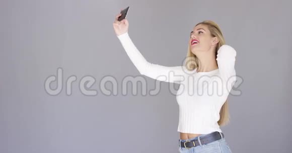 一位年轻的金发女人摆姿势自拍视频的预览图