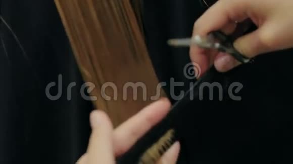 女理发师手握手指间锁毛梳子和剪刀特写视频的预览图