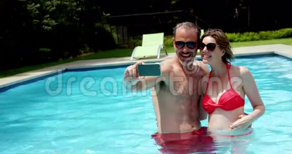 情侣在游泳池里用手机自拍视频的预览图