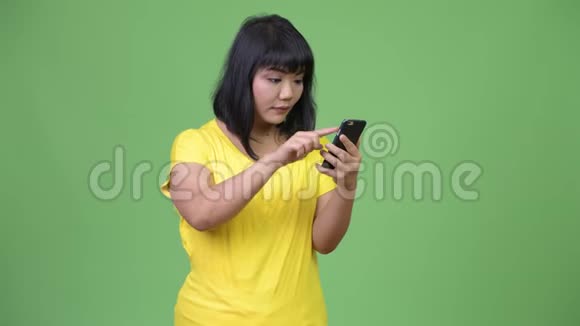 美丽快乐的亚洲女人用电话得到好消息视频的预览图