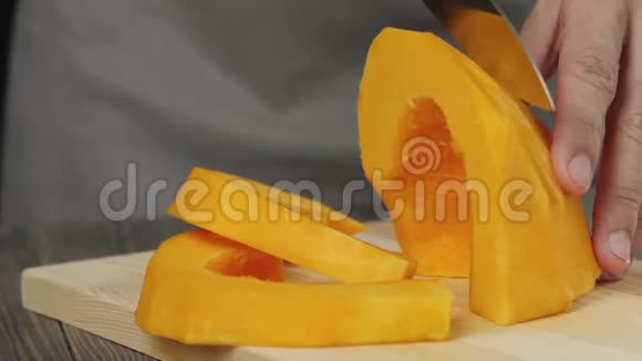 奶油南瓜汤烹饪健康食品厨师在木桌上把一个新鲜的橙色南瓜切成薄片侧视4K视频的预览图