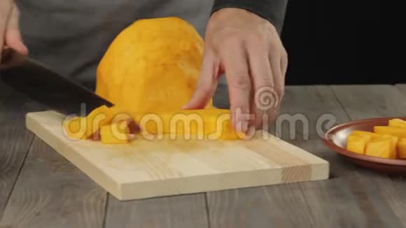 奶油南瓜汤烹饪健康食品厨师在木桌上把一个新鲜的橙色南瓜切成薄片侧视视频的预览图