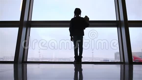 小女孩在机场大窗户附近等待登机视频的预览图