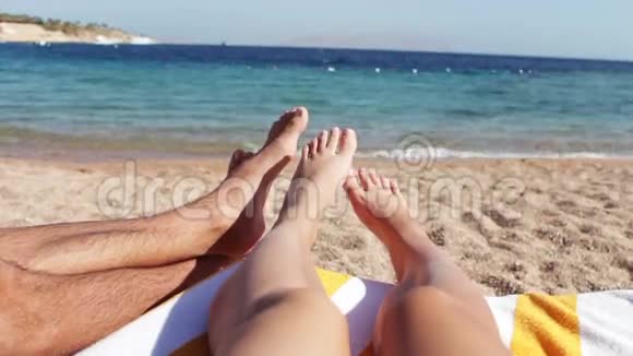 腿躺在沙滩上的阳光休息室视频的预览图