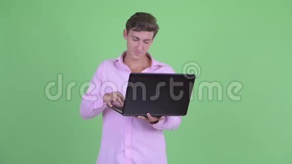 快乐年轻英俊的商人使用笔记本电脑视频的预览图
