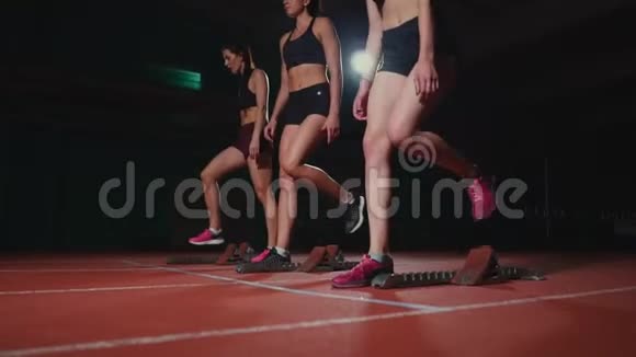田径场的女跑运动员在比赛前蹲在起点动作缓慢视频的预览图