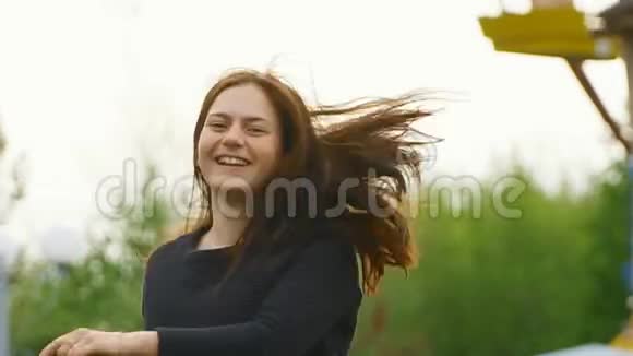 迷人的女孩穿着公园里的衬衫阳光明媚微笑视频的预览图