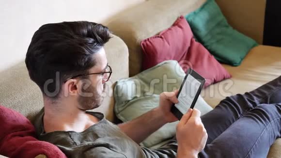 帅哥在沙发上看电子书视频的预览图