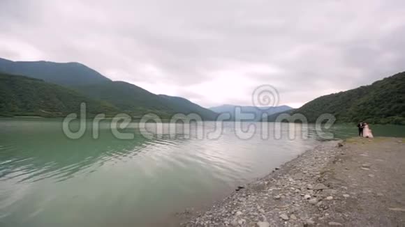 在河和山的背景下相爱的一对视频的预览图