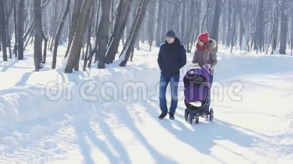 冬天在公园散步的快乐的年轻家庭视频的预览图