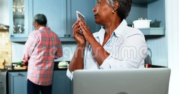 老两口在厨房里用手机说话视频的预览图