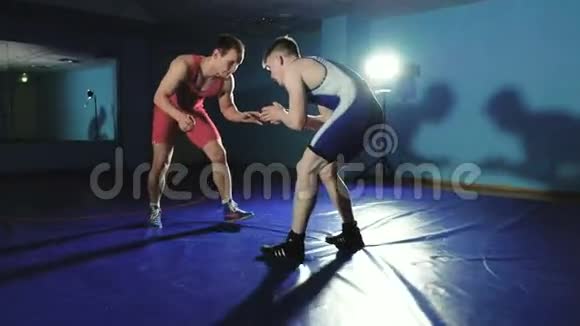 两个摔跤手希腊罗马摔跤在蓝色背景慢莫视频的预览图