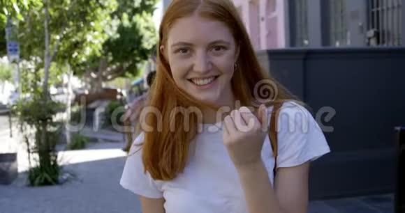 一位年轻女子在街上微笑的肖像视频的预览图