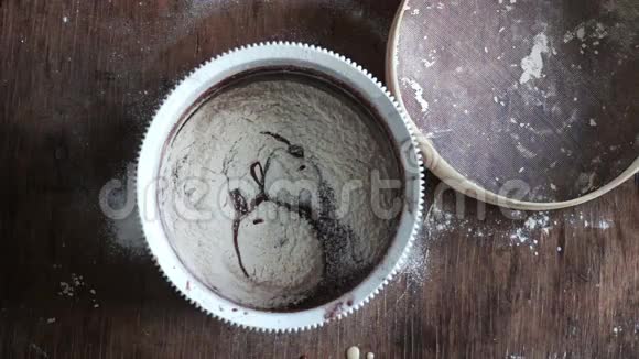 在白色塑料碗中用勺子搅拌巧克力饼干面团视频的预览图
