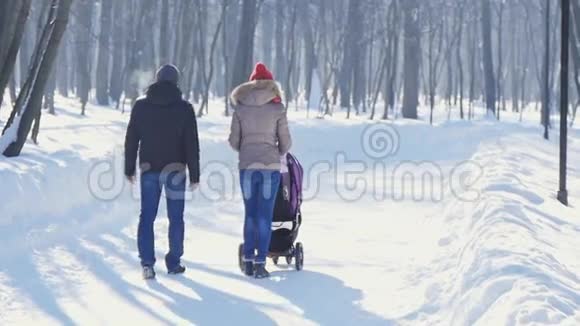 冬天在公园散步的快乐的年轻家庭视频的预览图