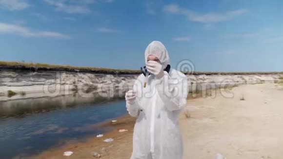 穿着防护服和呼吸器的人观察试管中水的化学反应视频的预览图