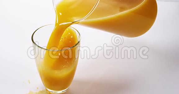 在白色背景下将橙汁倒入玻璃中视频的预览图