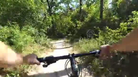 夏天骑自行车的女孩骑在树林里的土路上视频的预览图