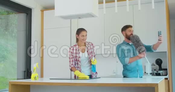 男人和女人作为一个专业的清洁工在厨房工作期间玩得很开心视频的预览图