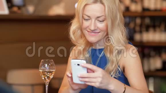 酒吧或餐馆里有智能手机的女人视频的预览图