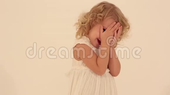 可爱可爱的可爱的小女孩金色卷发穿着白色连衣裙在玩捉迷藏视频的预览图