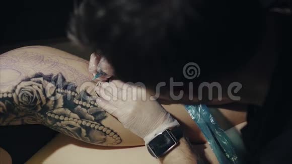 手套上纹身图案的纹身艺术家的特写视频的预览图