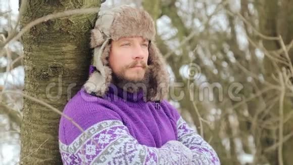 有胡子的年轻英俊男子的肖像冬天树林里长胡子的人视频的预览图