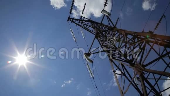 高压电源塔架对抗蓝天和太阳光具有天空背景的高压塔高压电源线视频的预览图