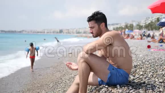 坐在海滩上的年轻人视频的预览图