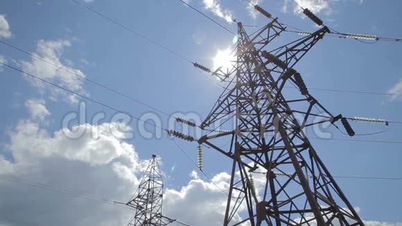 高压电源塔架对抗蓝天和太阳光具有天空背景的高压塔高压电源线视频的预览图