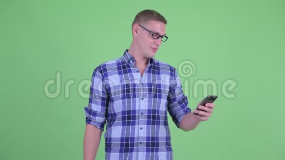 快乐的年轻潮男在用手机思考视频的预览图
