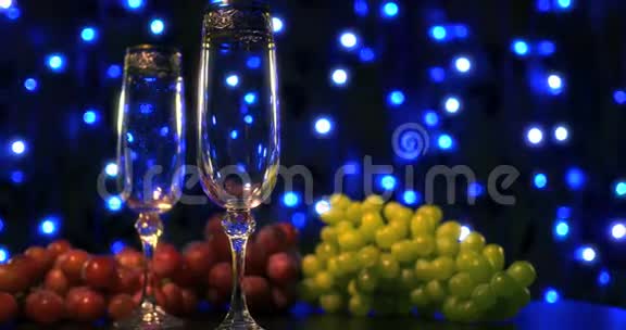 空杯和一瓶香槟放在蓝色背景上视频的预览图